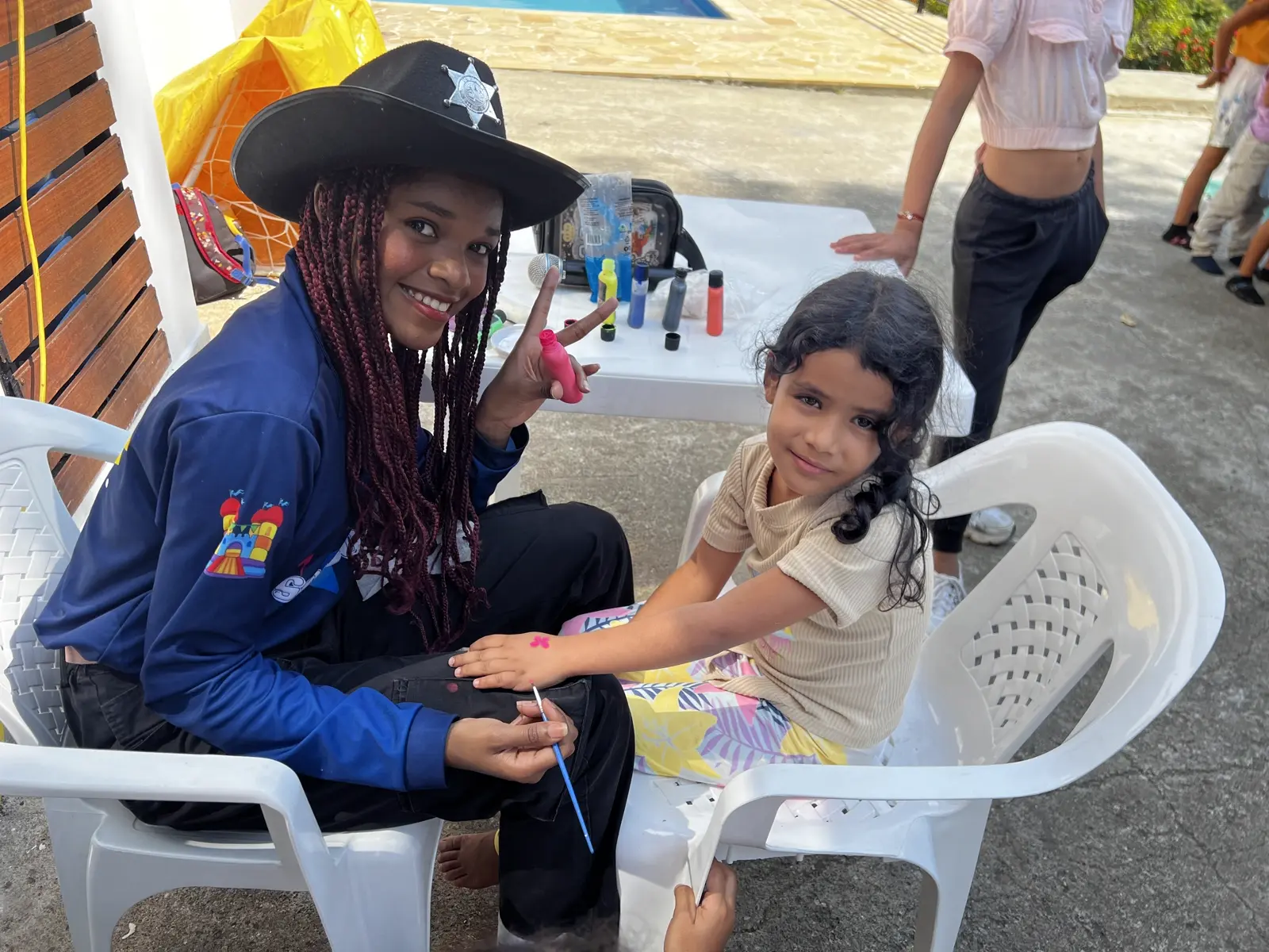 Niña recibiendo pintura artística durante una actividad recreativa